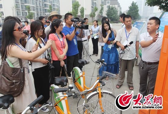 西线采访团采访了薛城区城市公共自行车服务系统，工作人员向记者们讲解公共自行车的详细情况。 记者 郭豪 摄。